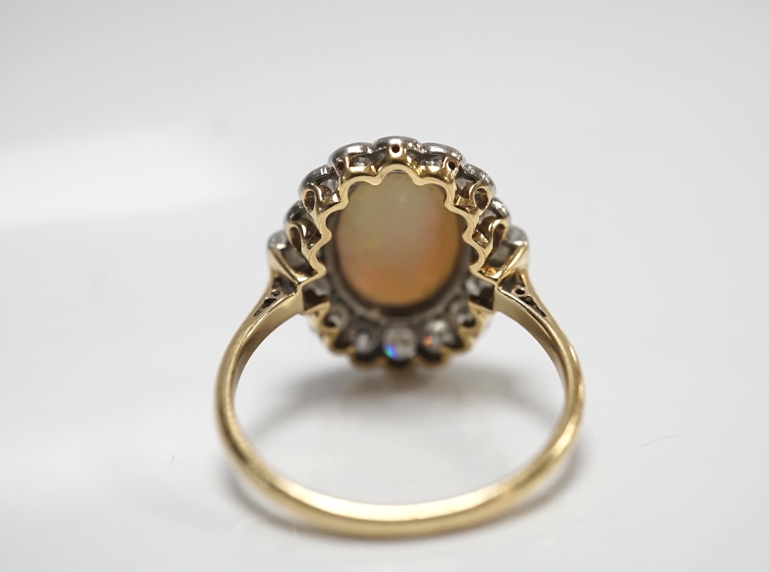 A mid 20th century 18ct, white opal, square and round cut diamond set oval cluster ring, size O, gross weight 3.3 grams. Condition - fair